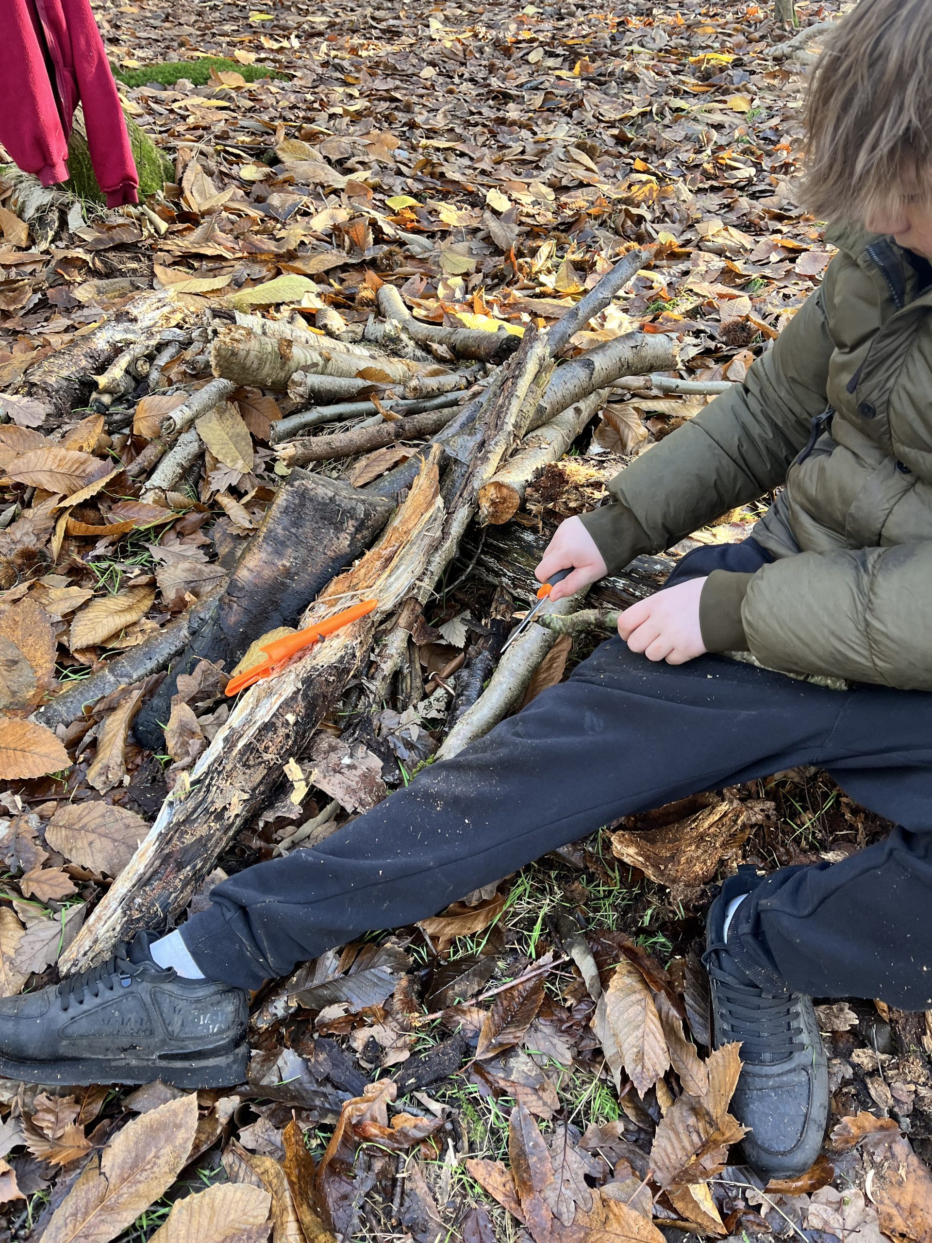 Young person whittling a stick with a knife